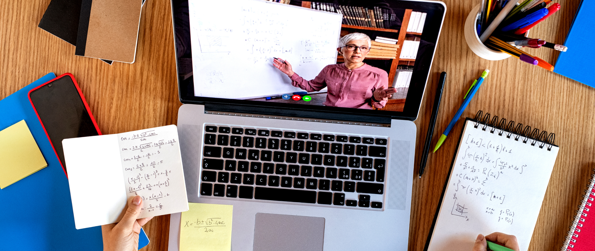 Włączony laptop. Na ekranie widoczna nauczycielka prowadząca zdalną lekcję matematyki. 