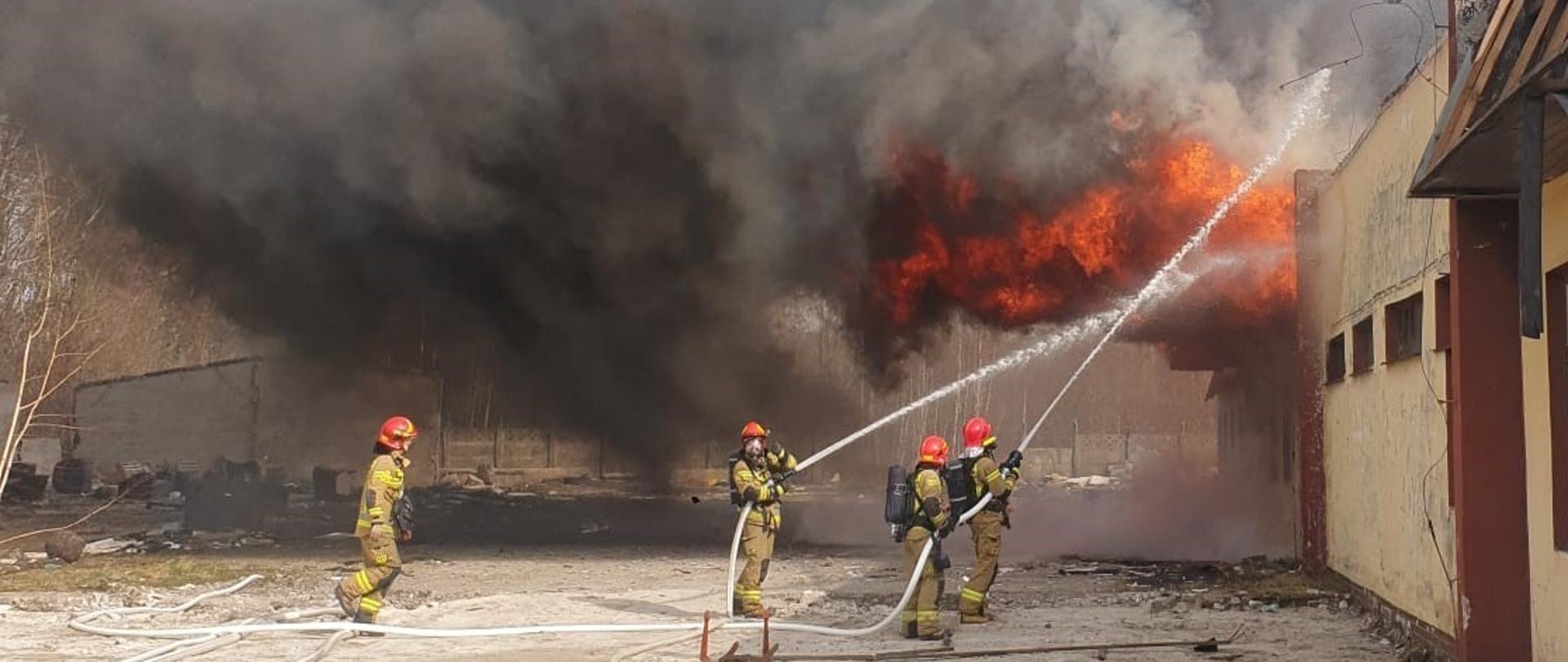 Strażacy gaszą pożar pustostanu hali magazynu.