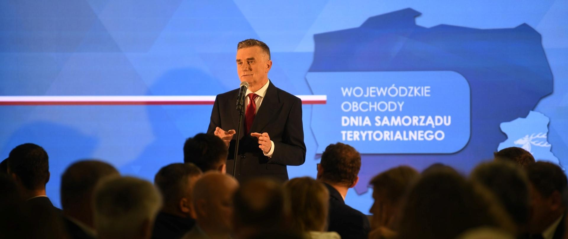 Wojewoda lubelski Lech Sprawka przemawia do uczestników wydarzenia siedzących na sali.