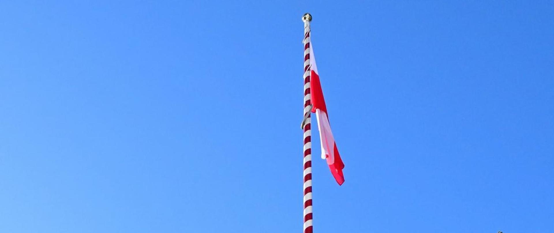 Flaga Polski wisi na maszcie.