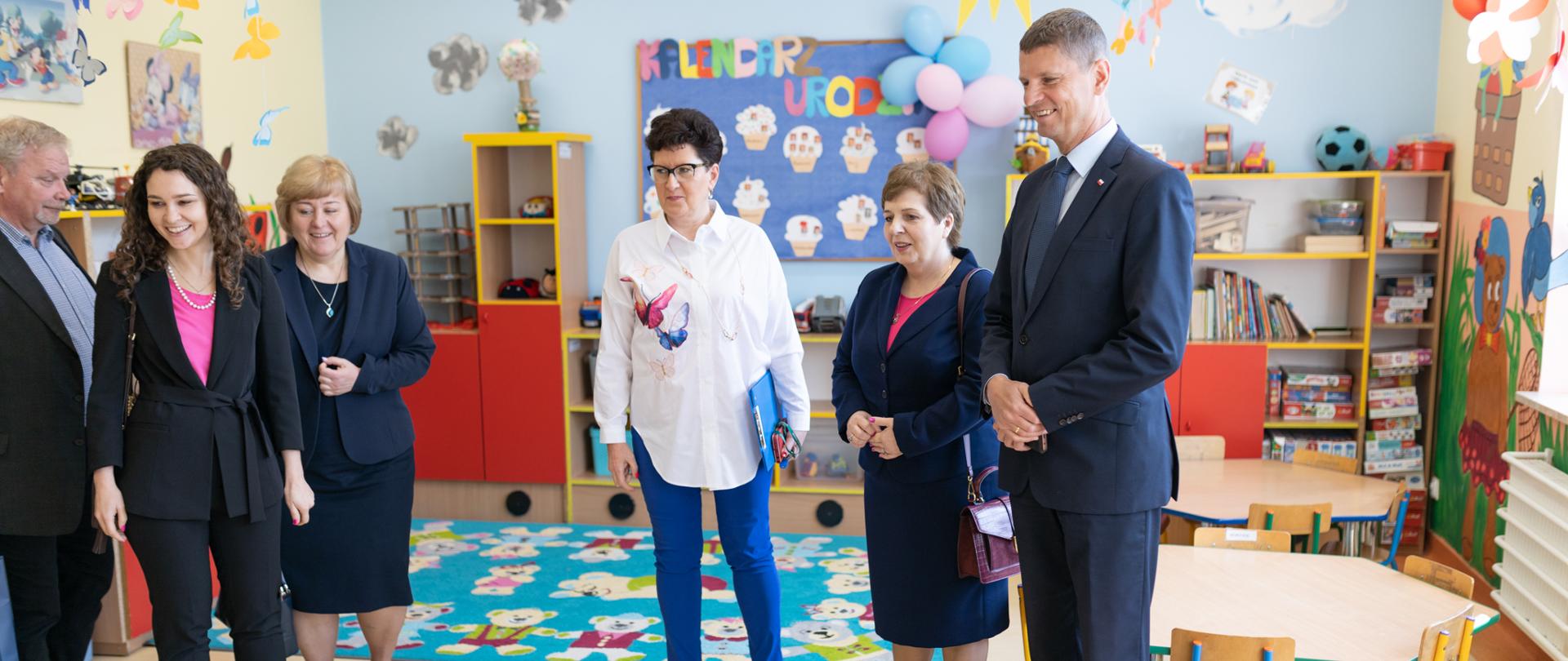 wiceminister Piontkowski, Justyna Orłowska oraz inni nauczyciele obserwują lekcje dzieci w czasie dnia nowych technologii w edukacji.
Dzień Nowych Technologii w Edukacji 