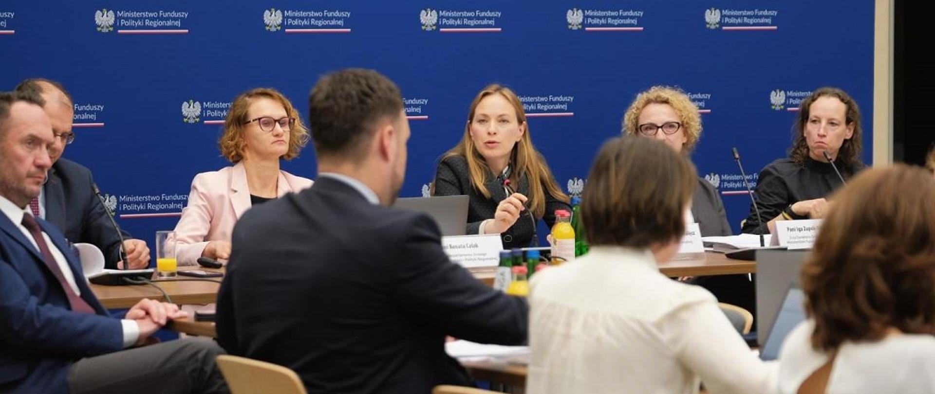 Minister funduszy i polityki regionalnej Katarzyna Pełczyńska-Nałęcz siedzi przy stole i mówi do mikrofonu, po jej prawej stronie siedzi dyrektor Departament Strategii w MFiPR Renata Calak