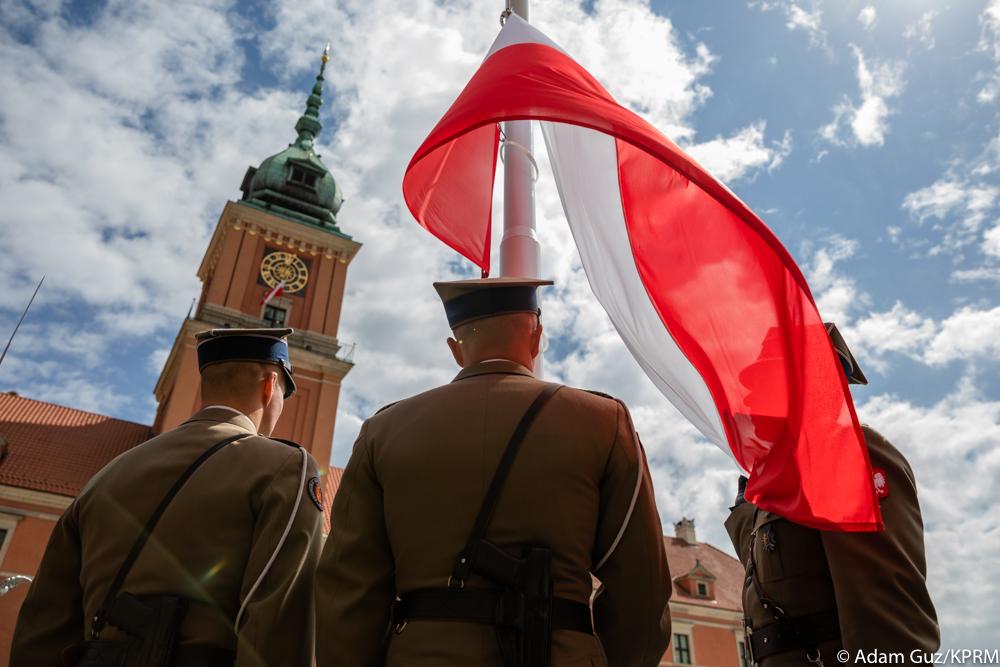 Zołnierze wraz z flagą Polski na maszcie.