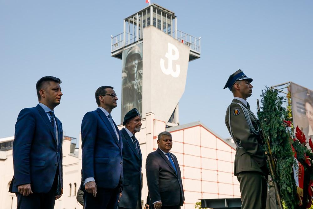 Minister Michał Dworczyk, premier Mateusz Morawiecki, minister Marek Suski, minister Joanna Kopcińska, a tle znak Polski Walczącej.