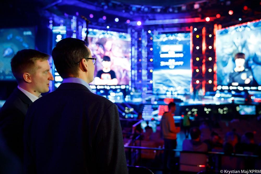 Premier Mateusz Morawiecki patrzy na arene z graczami.