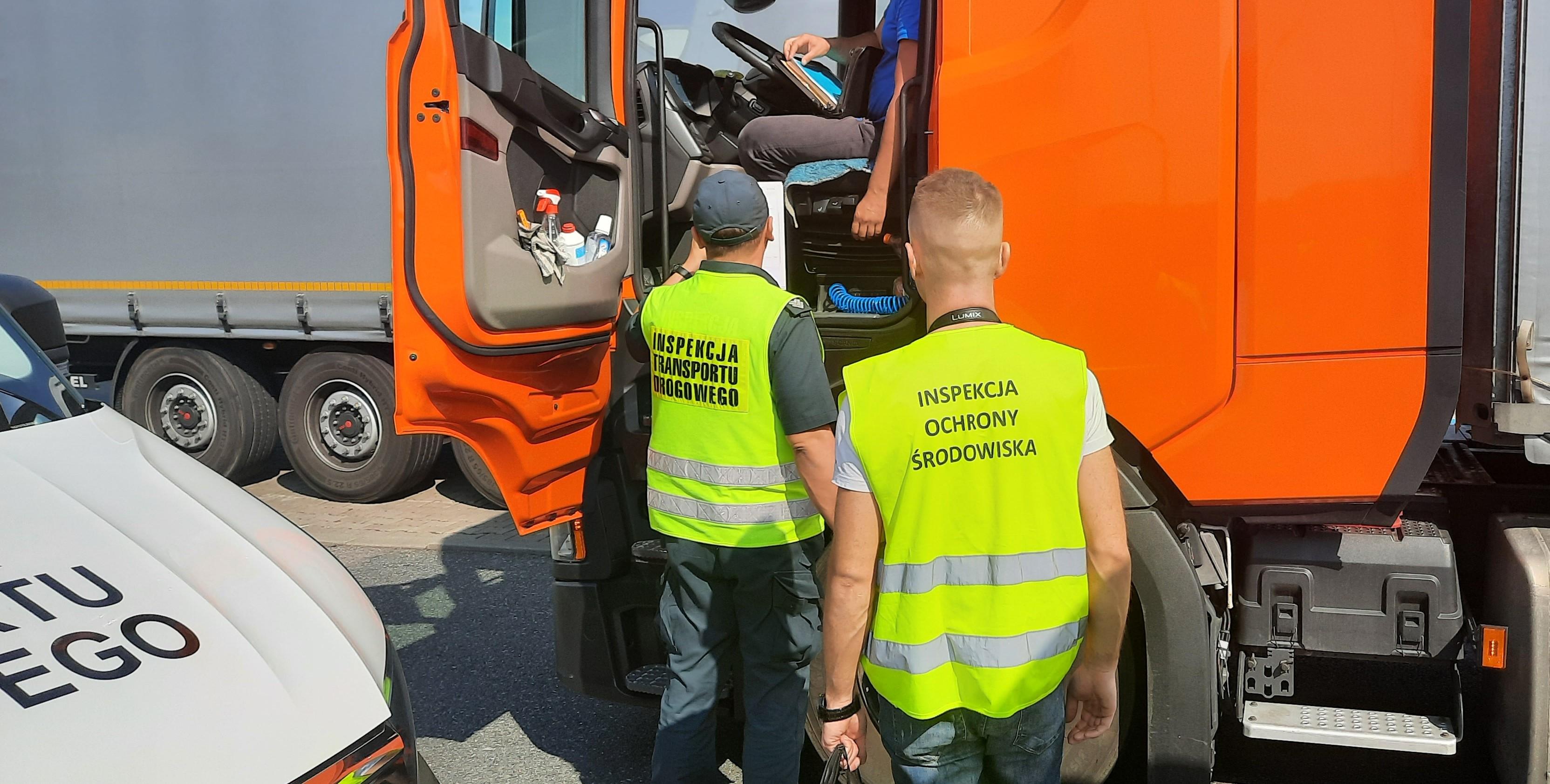 Inspektor Inspekcji Transportu Drogowego i Wojewódzkiego Inspektoratu Środowiska kontrolują ciężarówkę.