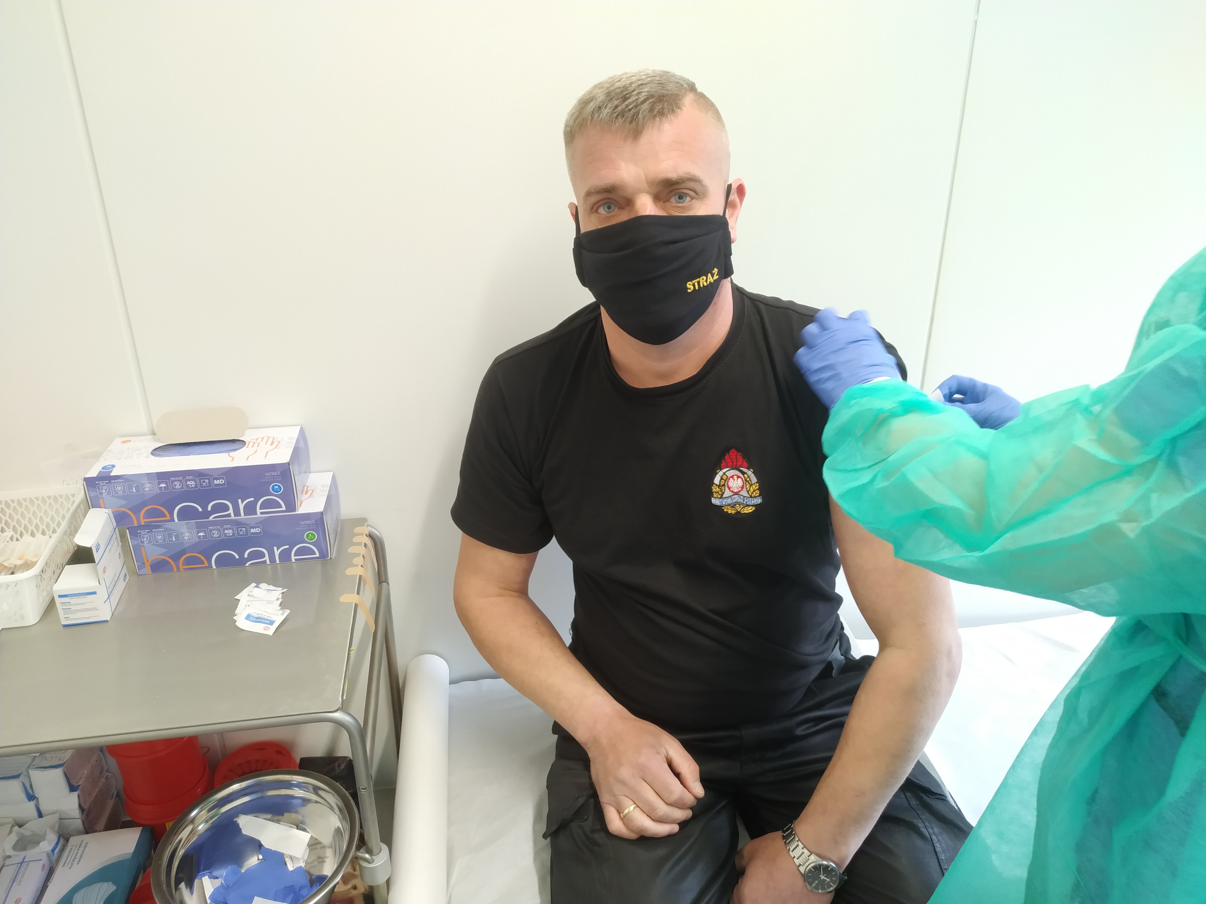 Zdjęcie przedstawia asp.sztab. Grzegorza Markiewicza podczas szczepień. 
