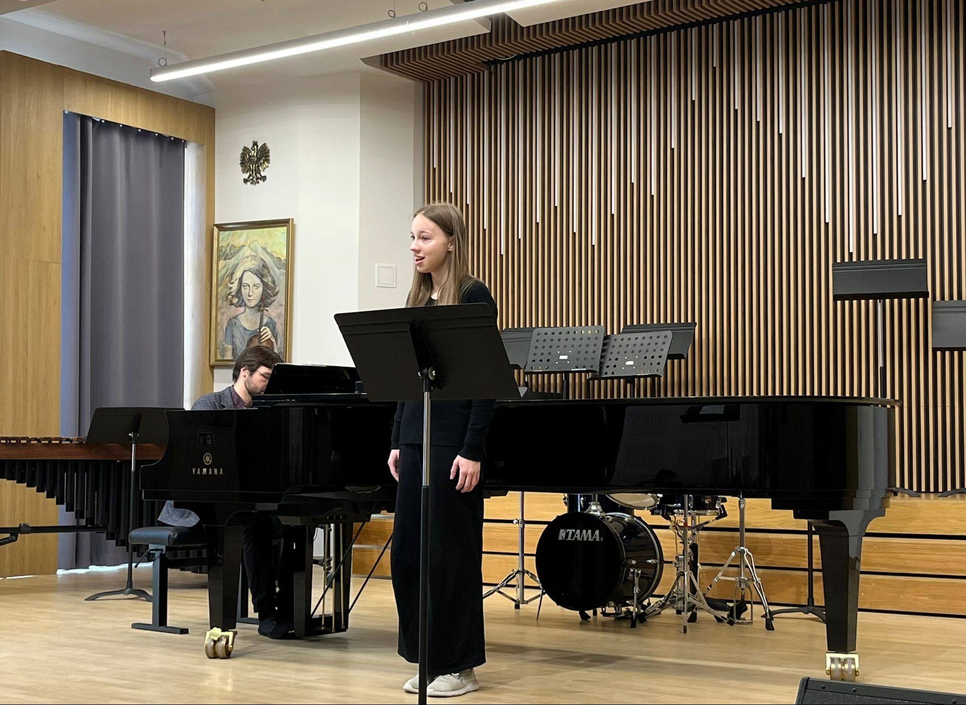 Na scenie uczennica śpiewająca kolędę, oraz pianista akompaniujący.