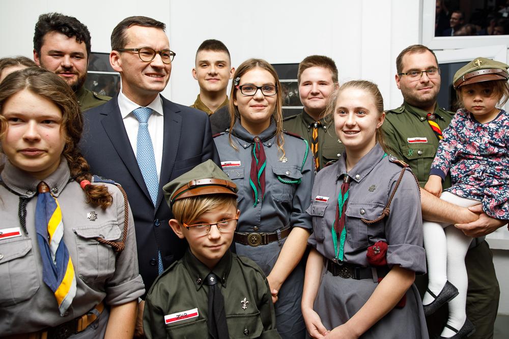 Premier Mateusz Morawiecki pozuje do zdjęcia z harcerzami.