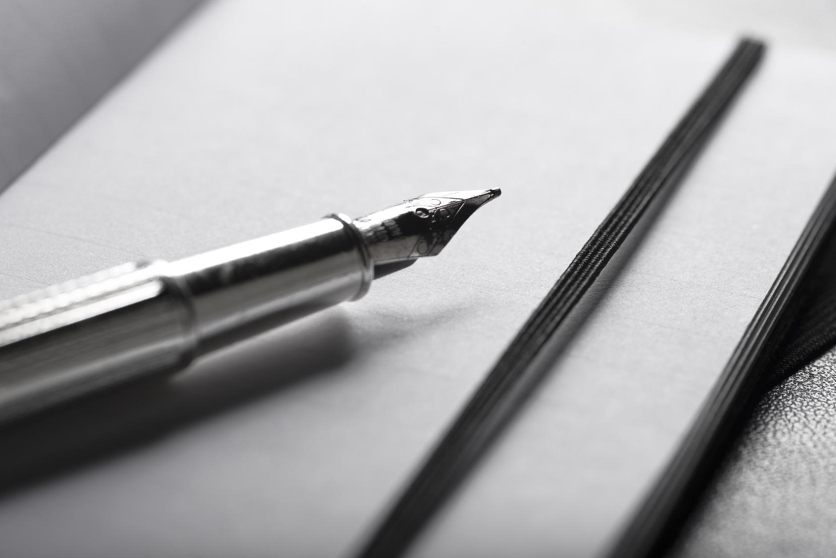 Pióro nad kartką papieru.