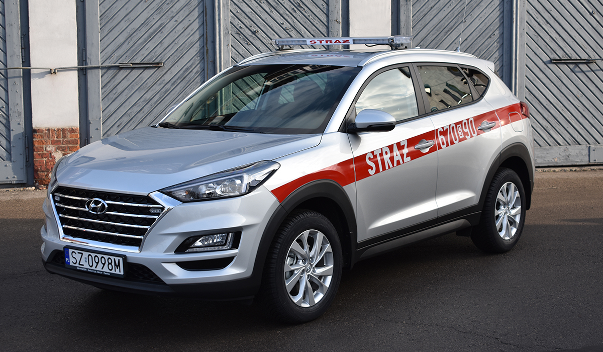Zdjęcie przedstawia samochód operacyjny - lekki Hyundai Tucson na tle budynku Komendy Miejskiej Państwowej Straży Pożarnej w Zabrzu