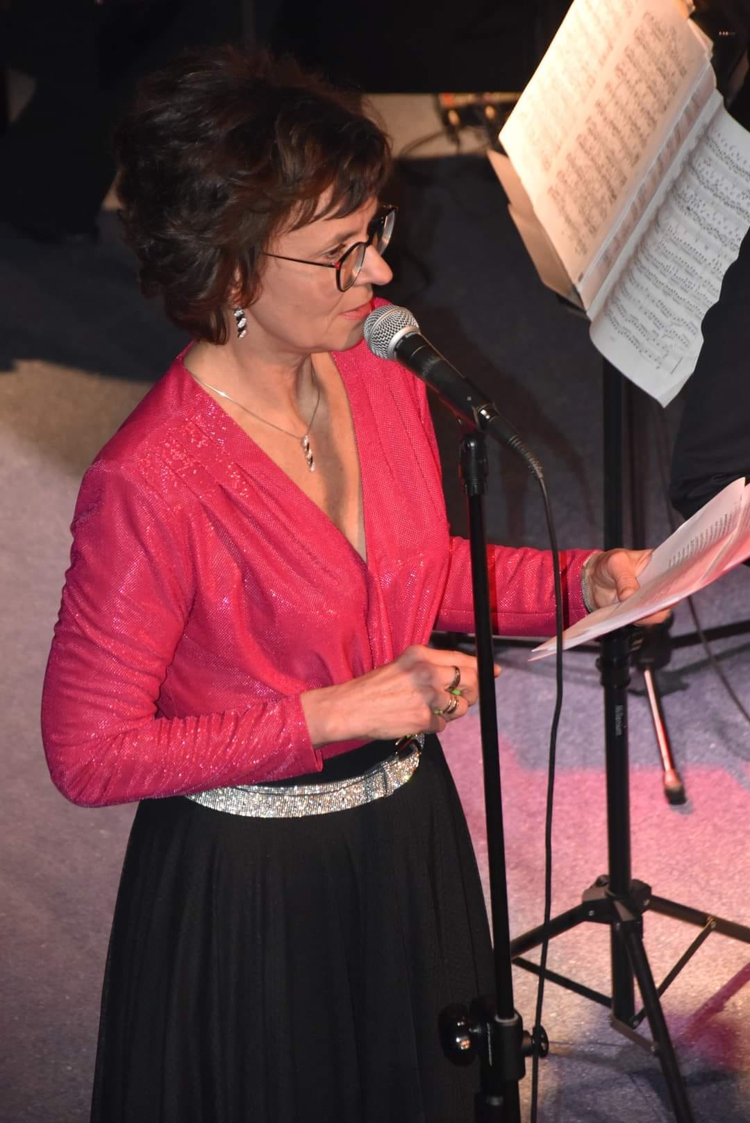 Dyrektor Szkoły Katarzyna Grzybowska podczas przwmówienia na scenie gostyńskiego domu kultury Hutnik. Ubrana w czerwoną bluzkę i czarną spódnicę. 