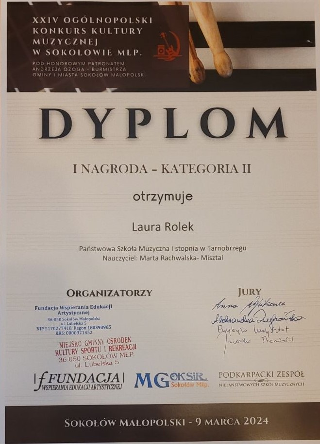 Dyplom za otrzymanie I Nagrody. Na górze ilustracja przedstawiająca pałeczki perkusyjne. Na dole po prawej stronie podpisy Jury, a po lewej stronie podpisy organizatorów.