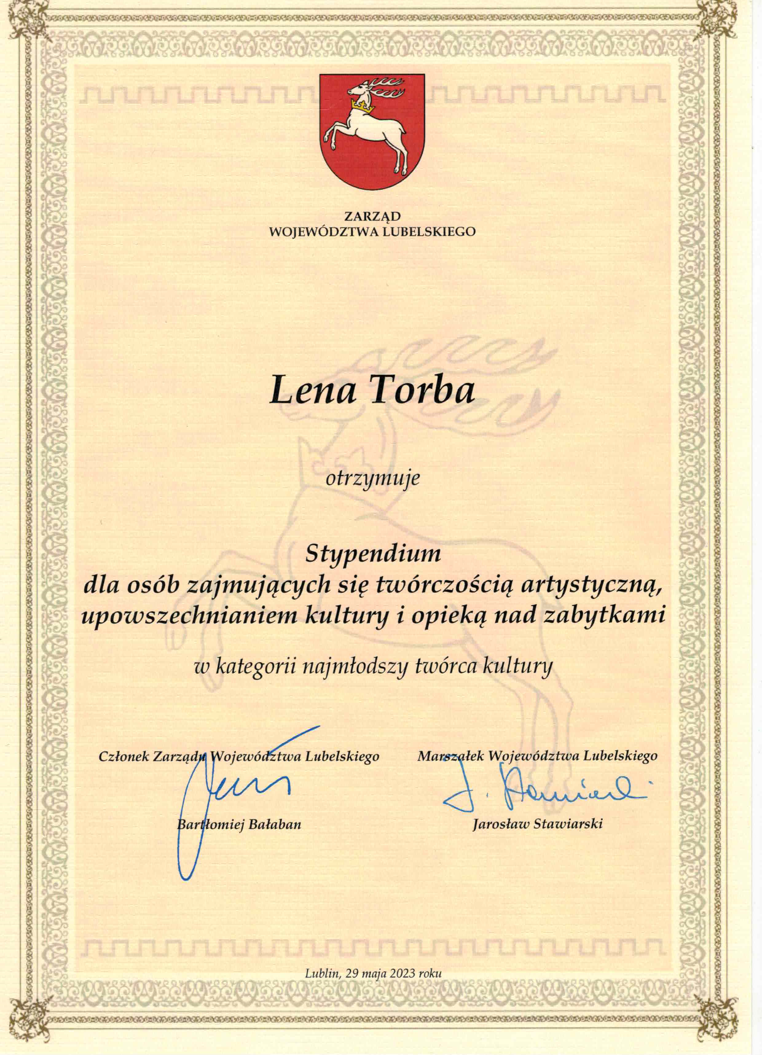 Zarząd Województwa Lubelskiego Lena Torba otrzymuje Stypendium dla osób zajmujących się twórczością artystyczną, upowszechnianiem kultury i opieka nad zabytkami, w kategorii najmłodszy twórca kultury Członek zarządu Województwa Lubelskiego - Bartłomiej Bałaban, Marszałek Województwa Lubelskiego - Jarosław Stawiarski Na górze dyplomu herb Lublina 