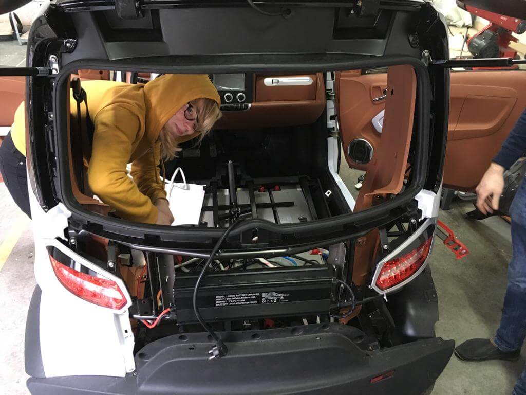 Młoda osoba pracuje przy aucie