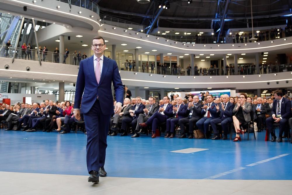 Premier Mateusz Morawiecki na sali plenarnej Kongresu 590 idzie w kierunku mównicy.