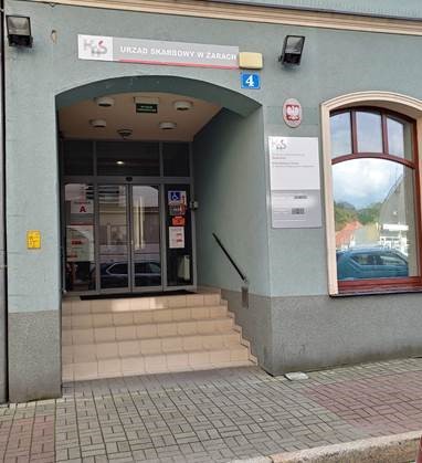 Wejście po schodach do budynku. Obok wejścia do budynku jest napis Krajowa Administracja Skarbowa i biały orzeł, czyli herb Polski. 