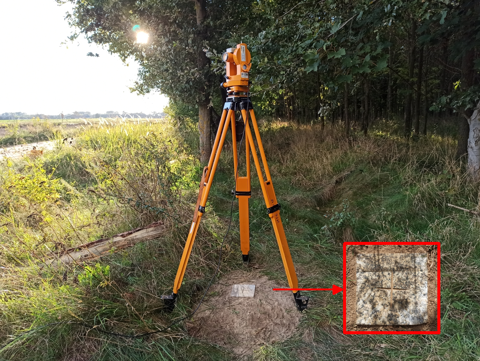 zdjęcie przedstawia widok na punkt osnowy magnetycznej klasy fundamentalnej z ustawionym tachimetrem wykorzystywanym do pomiarów magnetycznych