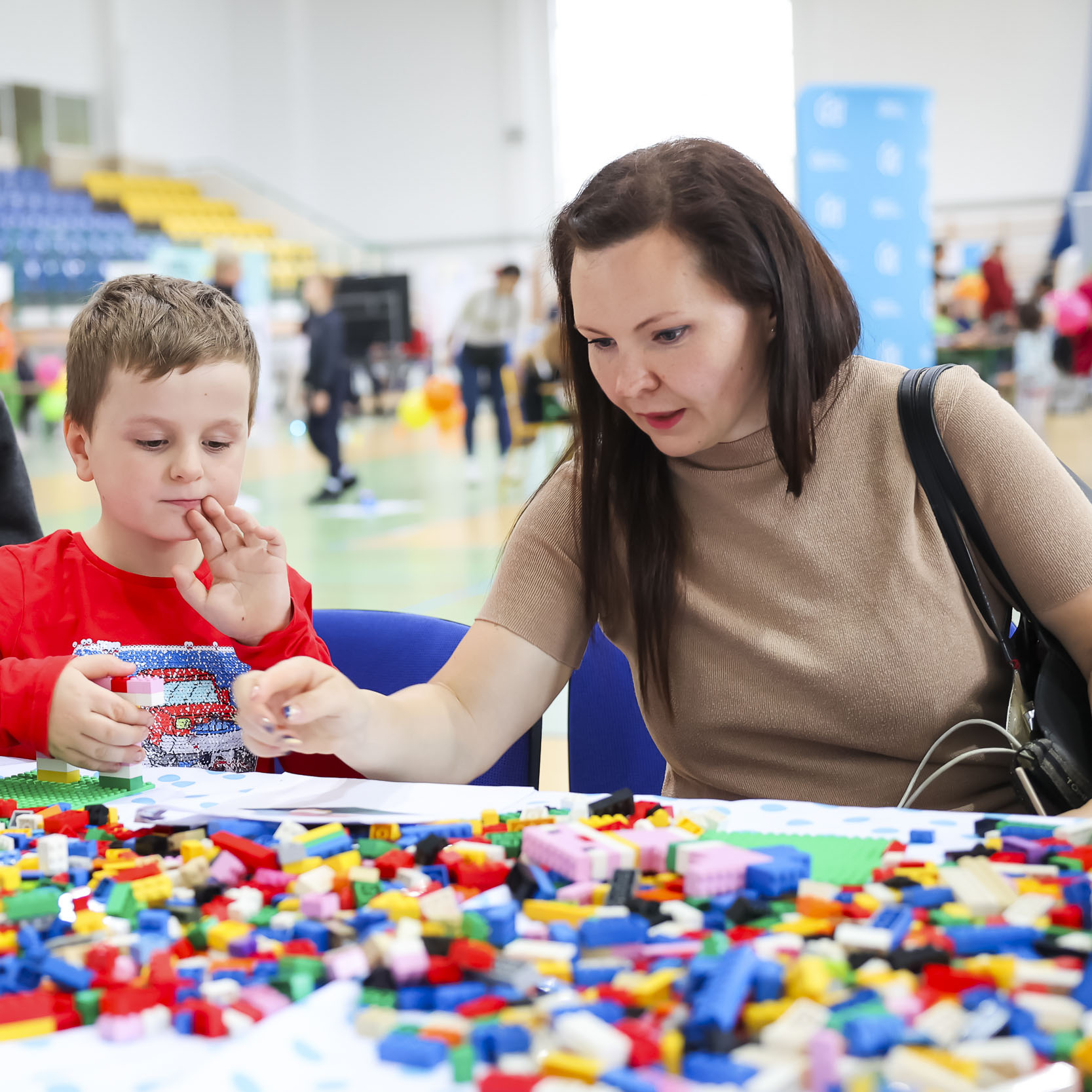 Dziecko i kobieta układający klocki lego w trakcie warsztatów