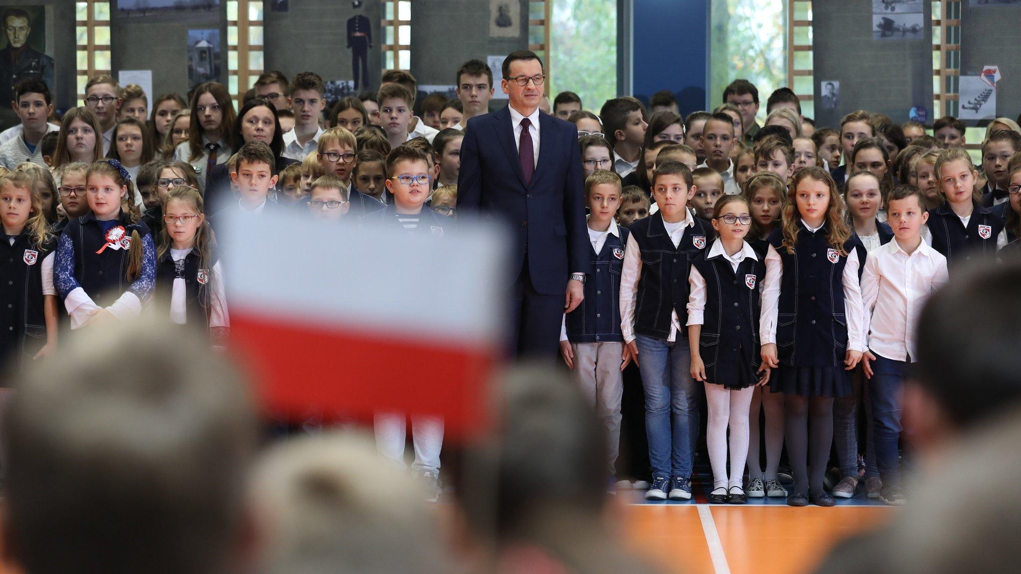 Premier stoi wśród dzieci.