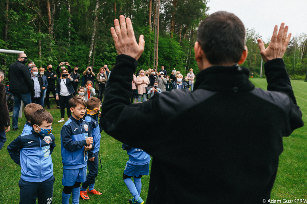 Premier Mateusz Morawiecki podczas treningu piłkarskiego wita się z dziećmi.