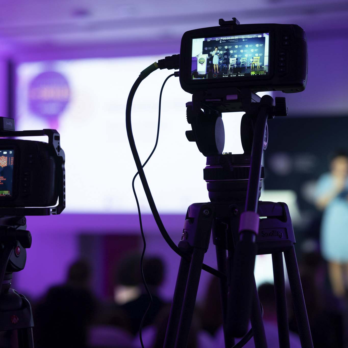 Zbliżenie na kamery nagrywające Panią Annę Butrym która przemawia na scenie.