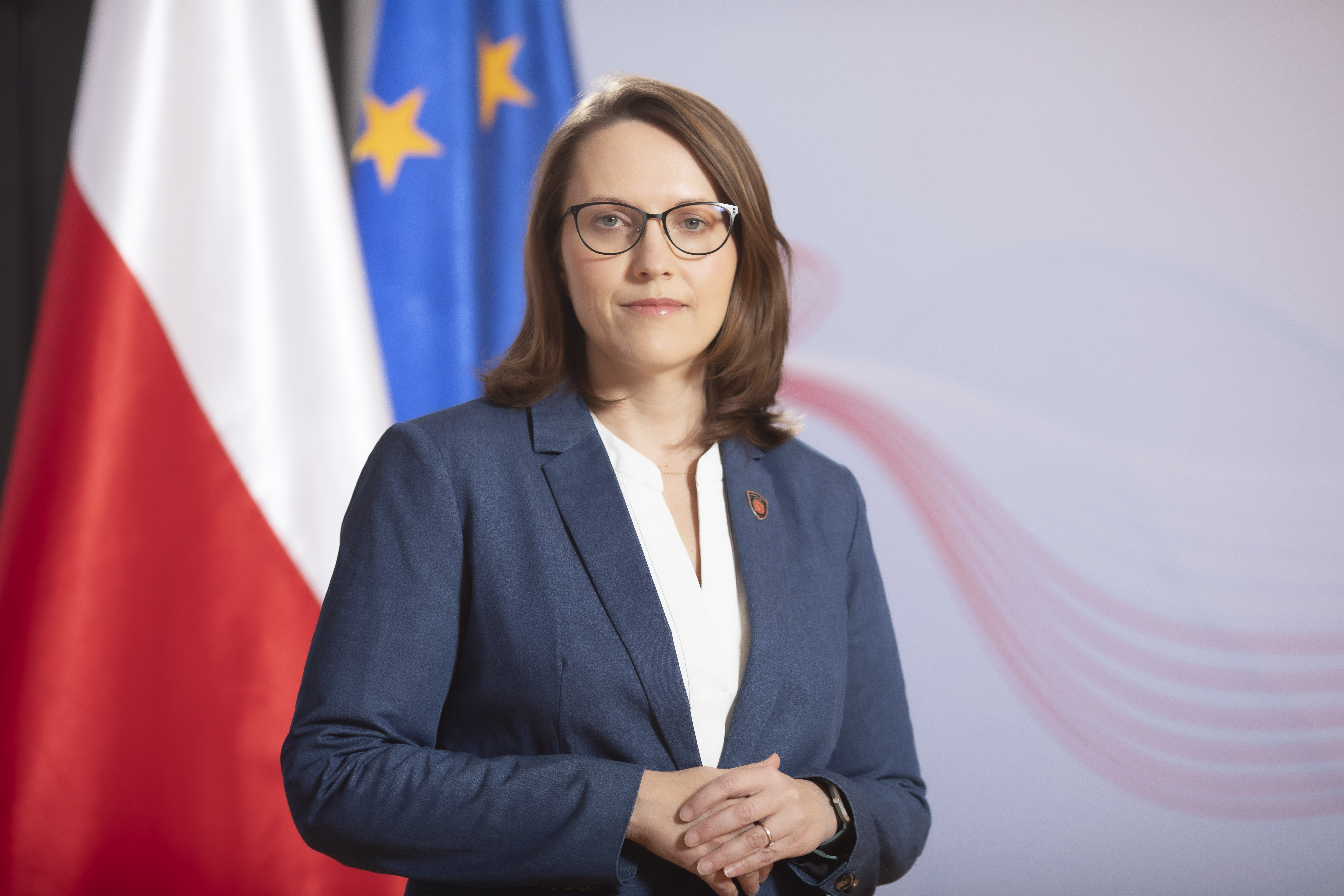 Magdalena Rzeczkowska - w tle flaga Polski i UE