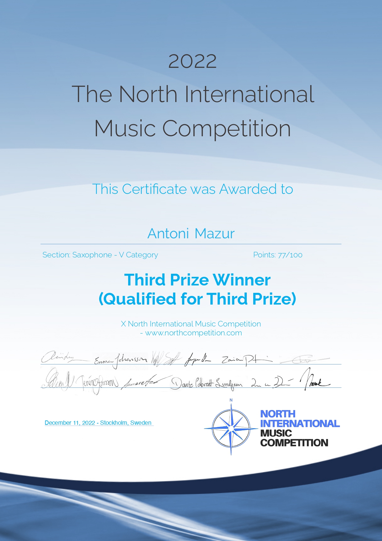 Dyplom konkursu w formacie A4 w górnej części tło jasnoniebieskie, w środkowej szarobiałe, na dole strony niebieskogranatowe, W górnej części napis 2022 The North Music Competition poniżej This Certificate was Awarded to Antoni Mazur. Third Prize Winner. Na dole strony podpisy członków jury oraz logotyp konkursu