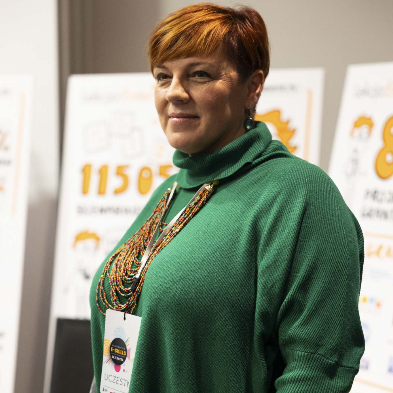 Kobieta patrzy w dal i uśmiecha się.