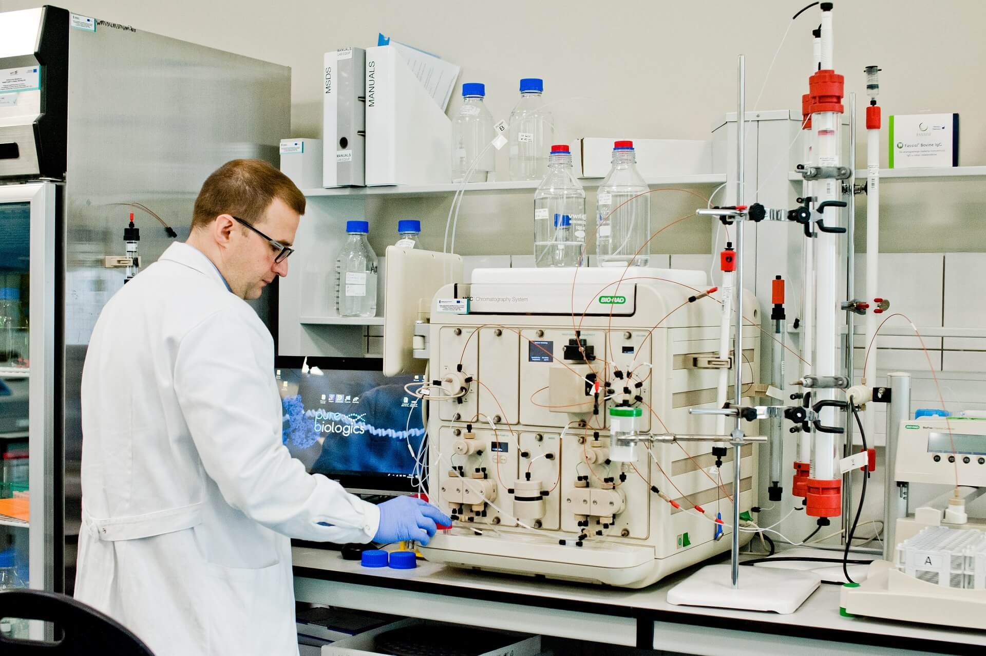 Maciej Mazurek, Director of the Department of Science and Innovation at Pure Biologics S.A., in a white coat, while working in the laboratory, at the table with the apparatus
