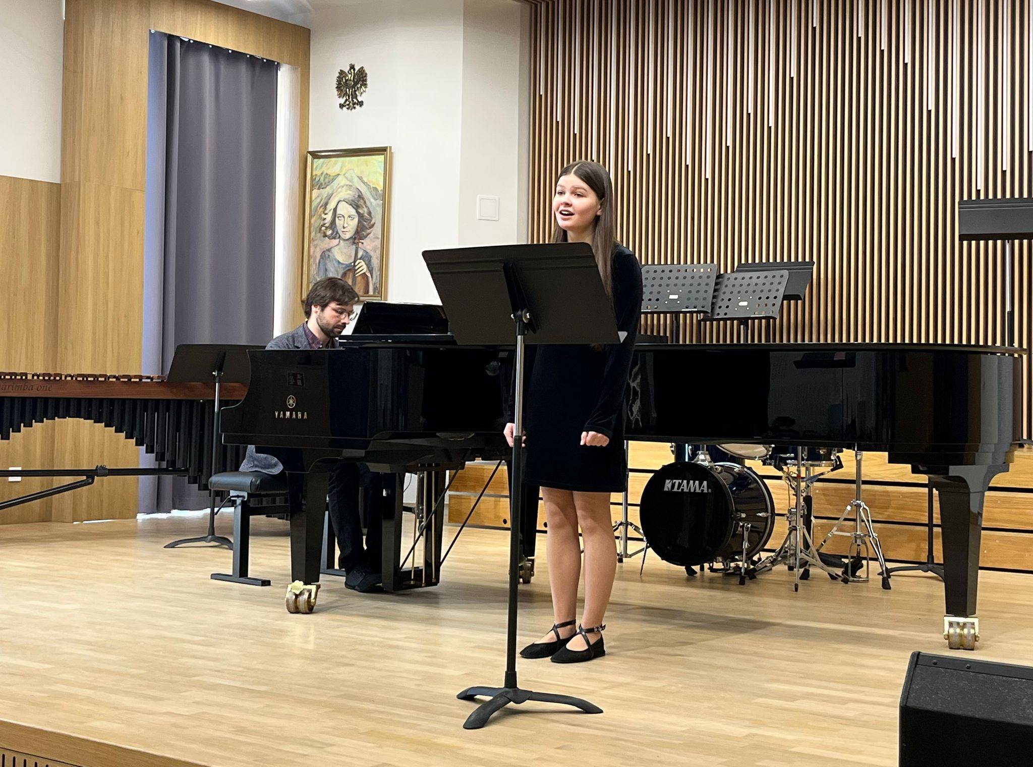 Na scenie uczennica śpiewająca kolędę, oraz pianista akompaniujący.