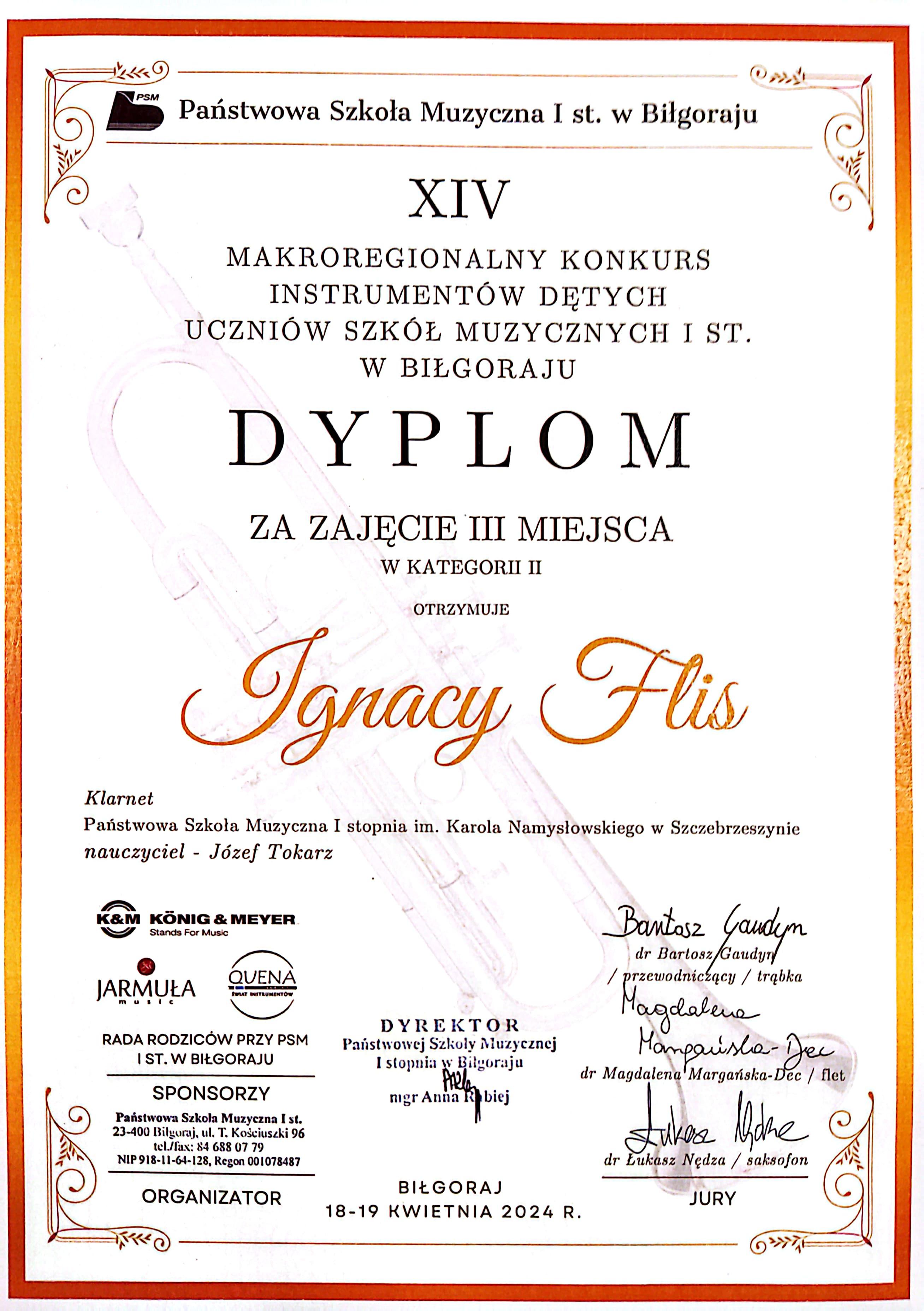 Na białym tle cień trąbki. Wokoło Złoty pasek. Napis Państwowa Szkoła Muzyczna I st. w Biłgoraju XIV Makroregionalny Konkurs Instrumentów Dętych Uczniów Szkół Muzycznych I st. w Biłgoraju, Dyplom za zajęcie III miejsca w kategorii II otrzymuje Ignacy Flis. Klarnet. Państwowa Szkoła Muzyczna I stopnia im. Karola Namysłowskiego w Szczebrzeszynie, nauczyciel - Józef Tokarz. Pod spodem pieczęć szkoły Muzycznej, loga sponsorów i podpisy komisji. 
