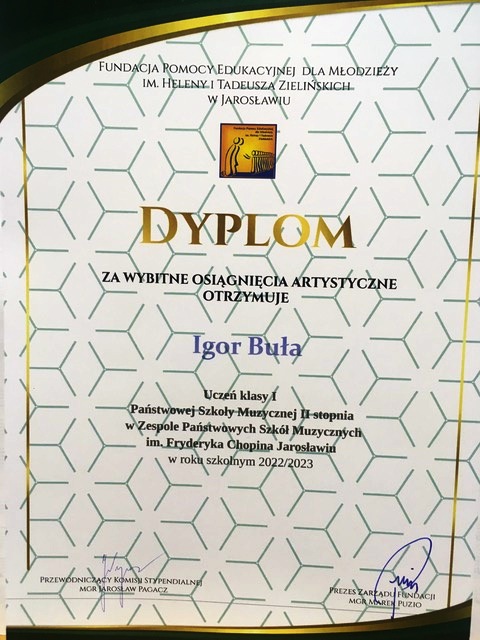 Dyplom na ozdobnym tle, ze stylizowaną na otwieraną kartę książki grafiką. Na górze napis FUNDACJA POMOCY EDUKACYJNEJ DLA MŁODZIEŻY IM. HELENY I TADEUSZA ZIELIŃSKICH W JAROSŁAWIU. Poniżej logotyp fundacji i złoty napis dużymi literami DYPLOM za wybitne osiągnięcia artystyczne otrzymuje Igor Buła Uczeń kl. I PSM II st. w ZPSM im. F. Chopina w Jarosławiu w roku szkolnym 2022/2023