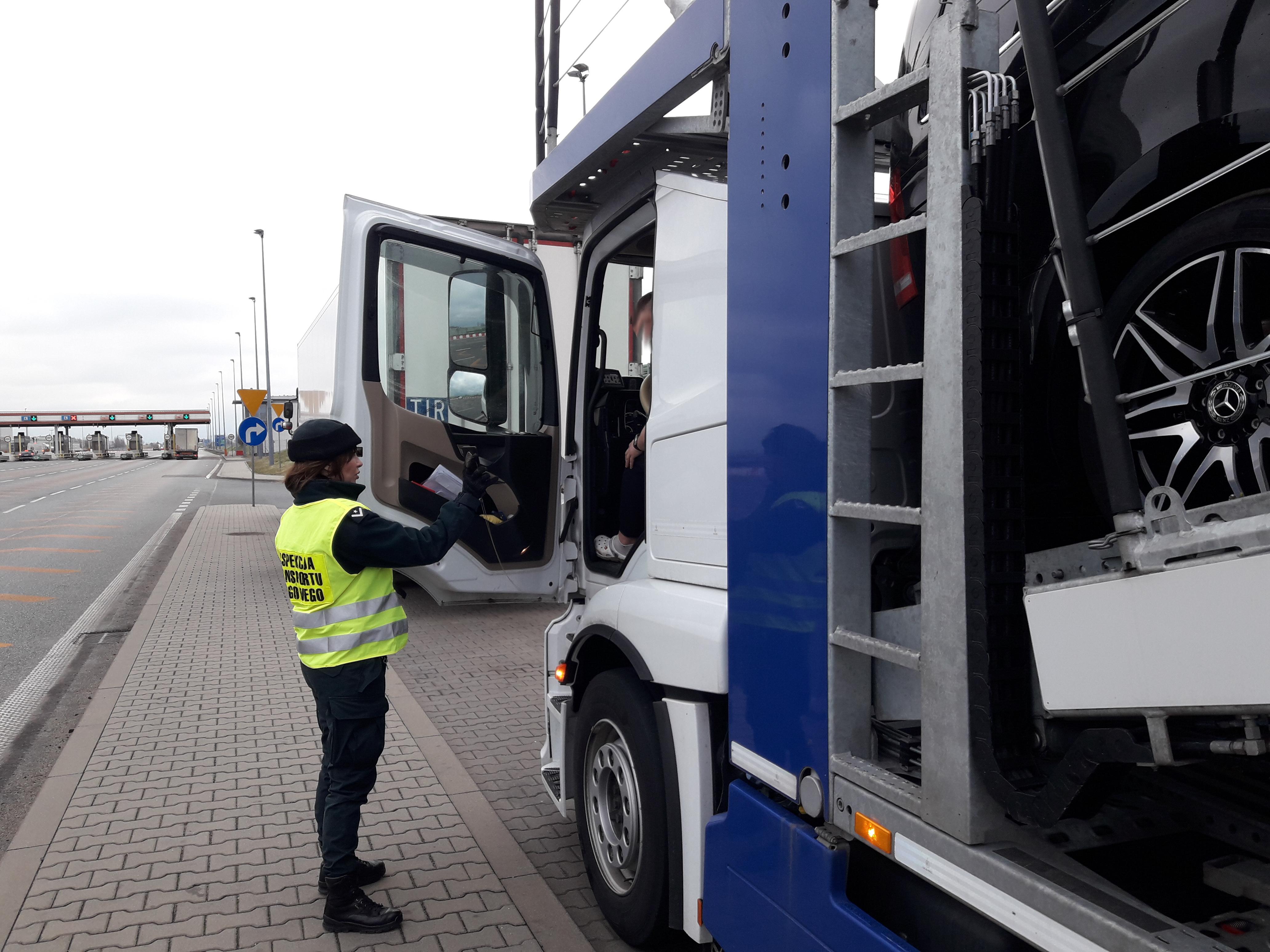 Inspektor podchodzi do szoferki ciężarówki.