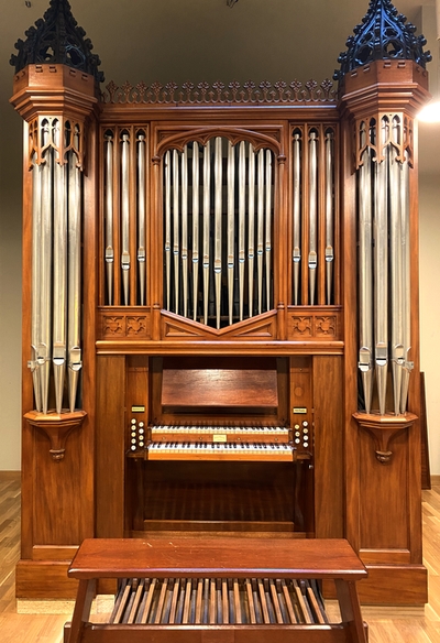 Grafika przedstawia organy piszczałkowe, dwumanuałowe z ławką i klawiaturą nożną - instrument znajdujący się w sali organowej im. Carla Loewe w ZPSM w Szczecinie