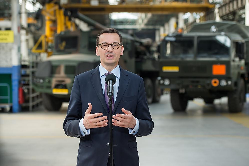 Premier Mateusz Morawiecki podczas przemówienia, a w samochody "Jelcz"..