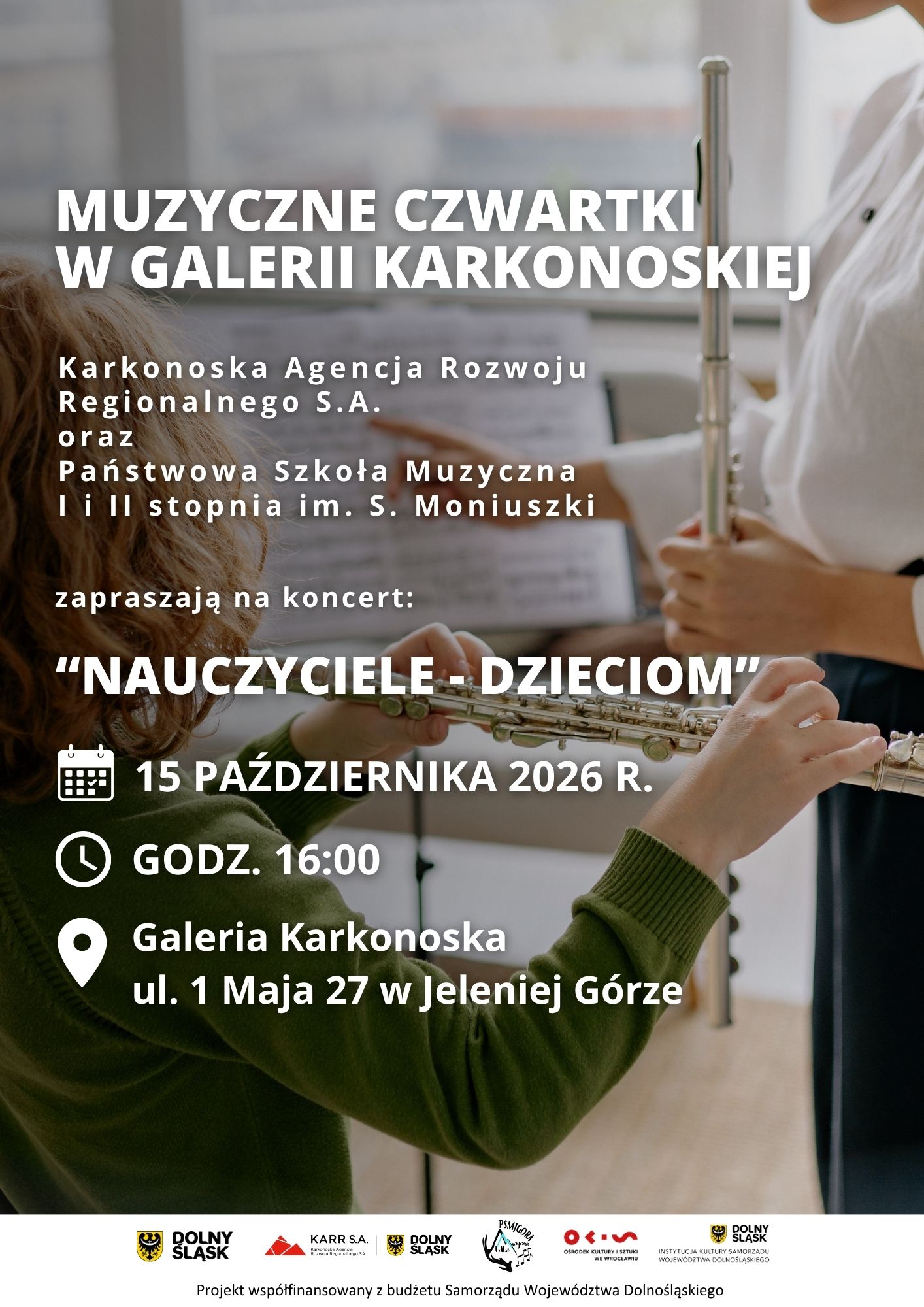 Plakat informacyjny o wydarzeniu „Muzyczne Czwartki w Galerii Karkonoskiej”. Na tle zdjęcia przedstawiającego osobę grającą na flecie poprzecznym umieszczono napisy w kolorze białym. Organizatorami koncertu zatytułowanego „Nauczyciele – Dzieciom” są Karkonoska Agencja Rozwoju Regionalnego S.A. oraz Państwowa Szkoła Muzyczna I i II stopnia im. S. Moniuszki. Wydarzenie odbędzie się 15 października 2026 roku o godzinie 16:00 w Galerii Karkonoskiej przy ulicy 1 Maja 27 w Jeleniej Górze. W dolnej części plakat zawiera logotypy oraz informację o współfinansowaniu projektu z budżetu Samorządu Województwa Dolnośląskiego.