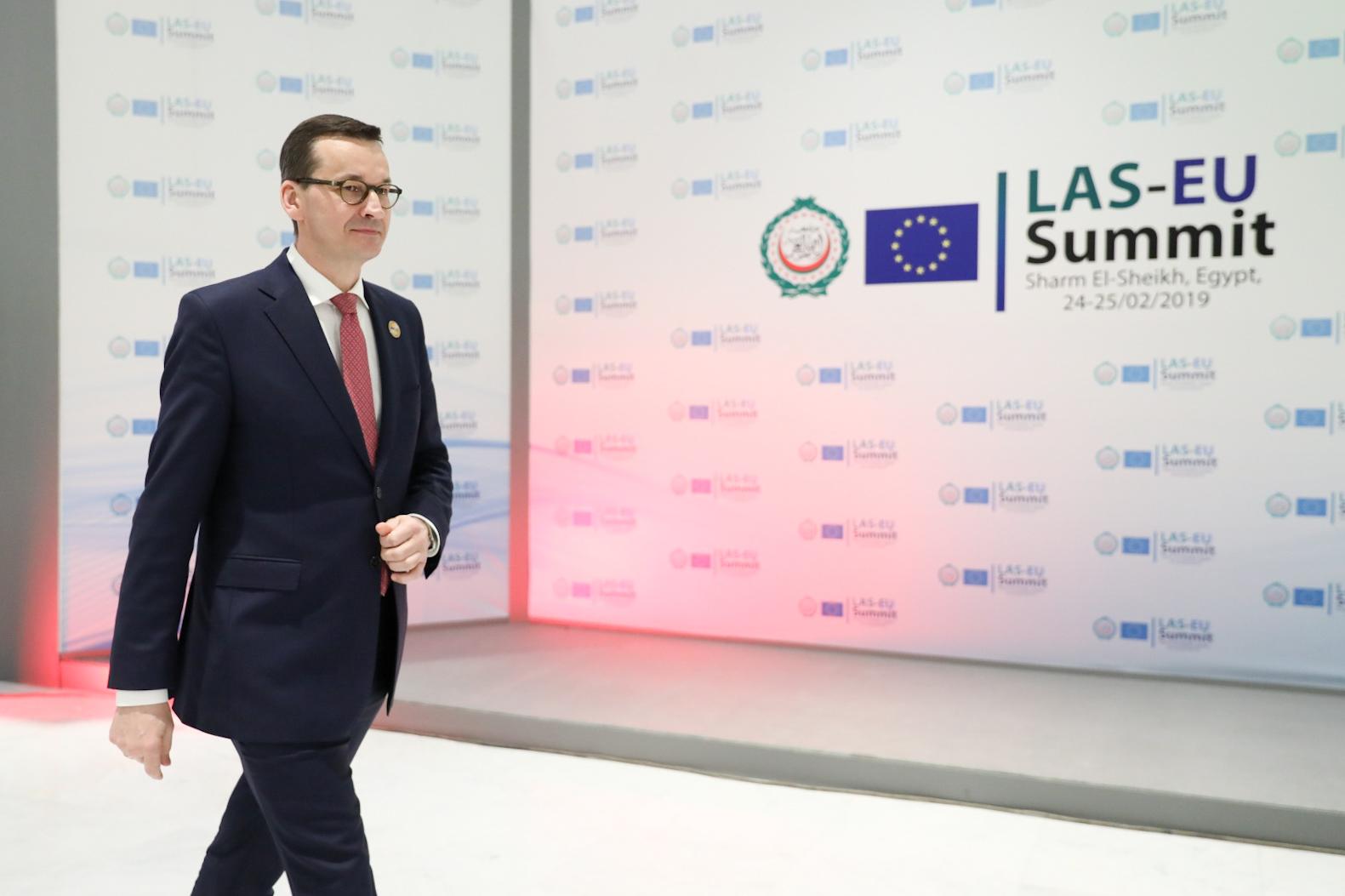 Premier Mateusz Morawiecki idzie na tle napisu LAS - EU Summit.