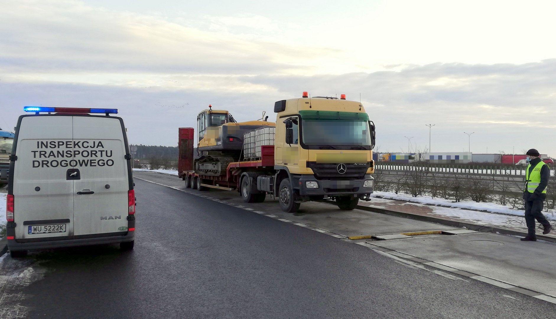 Inspektor kieruje ciężarówkę na wagi ITD.