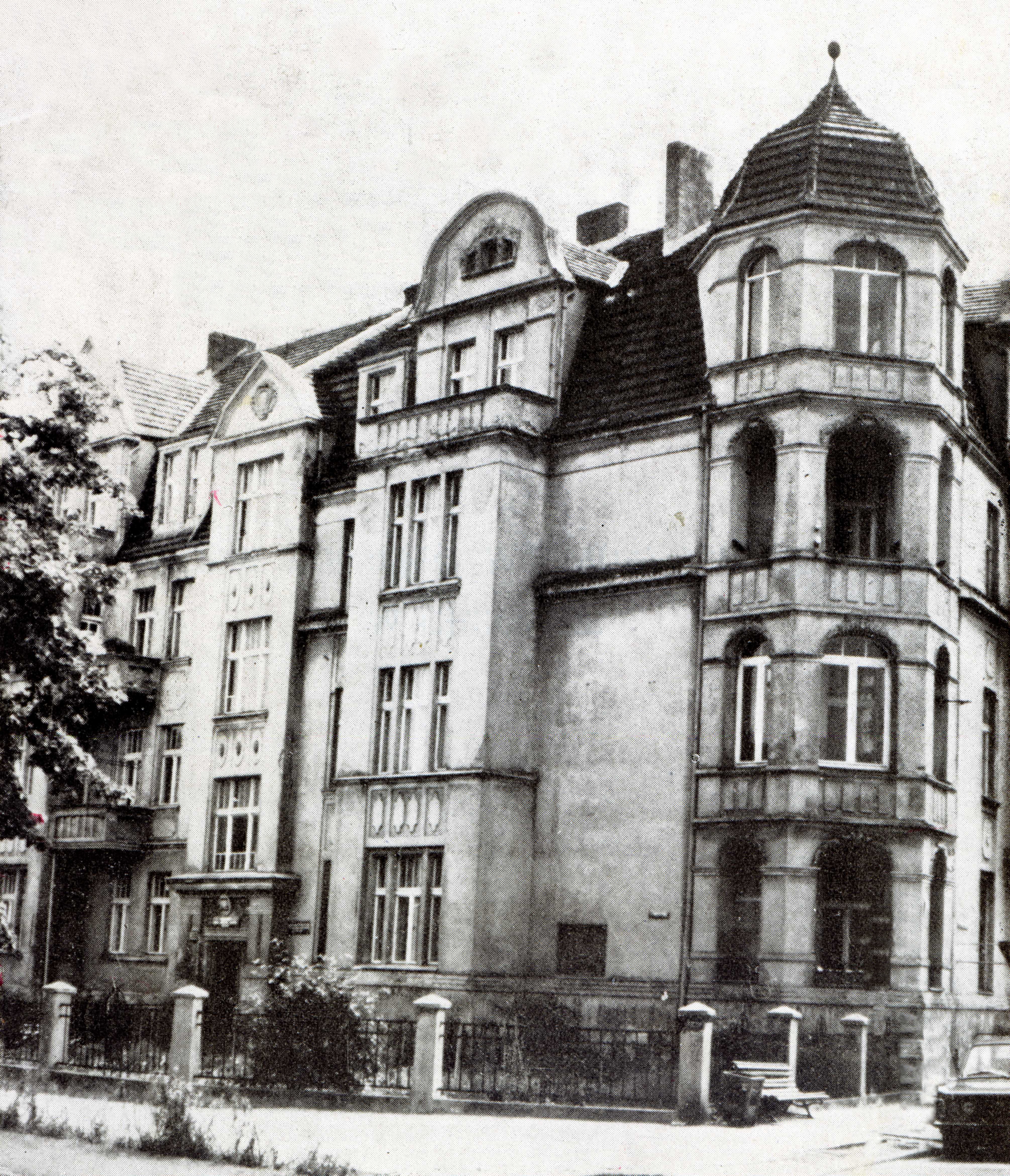 Zdjęcie czarno - białe przedstawiające kilku piętrową kamienicę, będącą poprzednią siedzibą Państwowej Szkoły Muzycznej