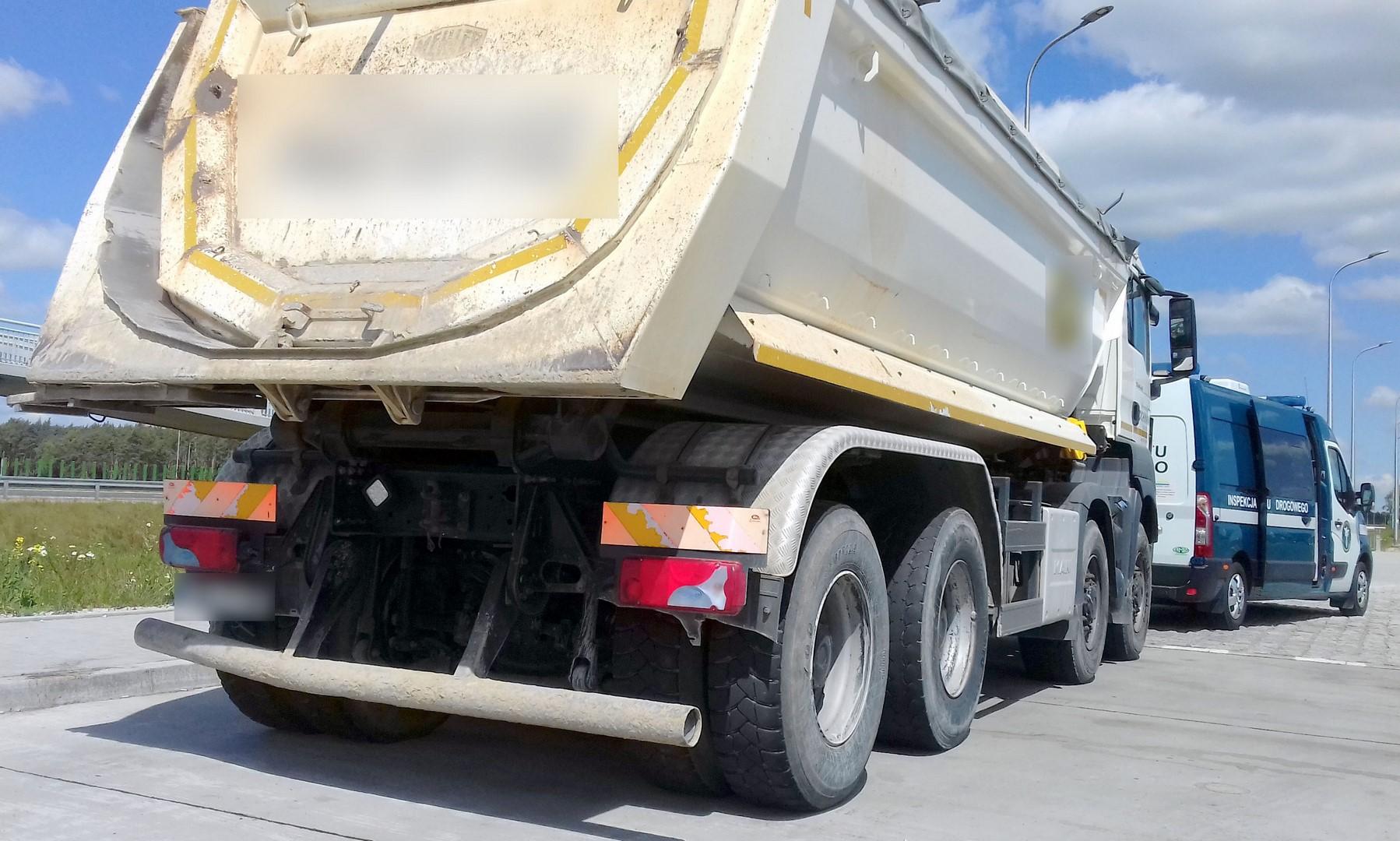 Zatrzymana wywrotka i stojący przed nią radiowóz ITD.