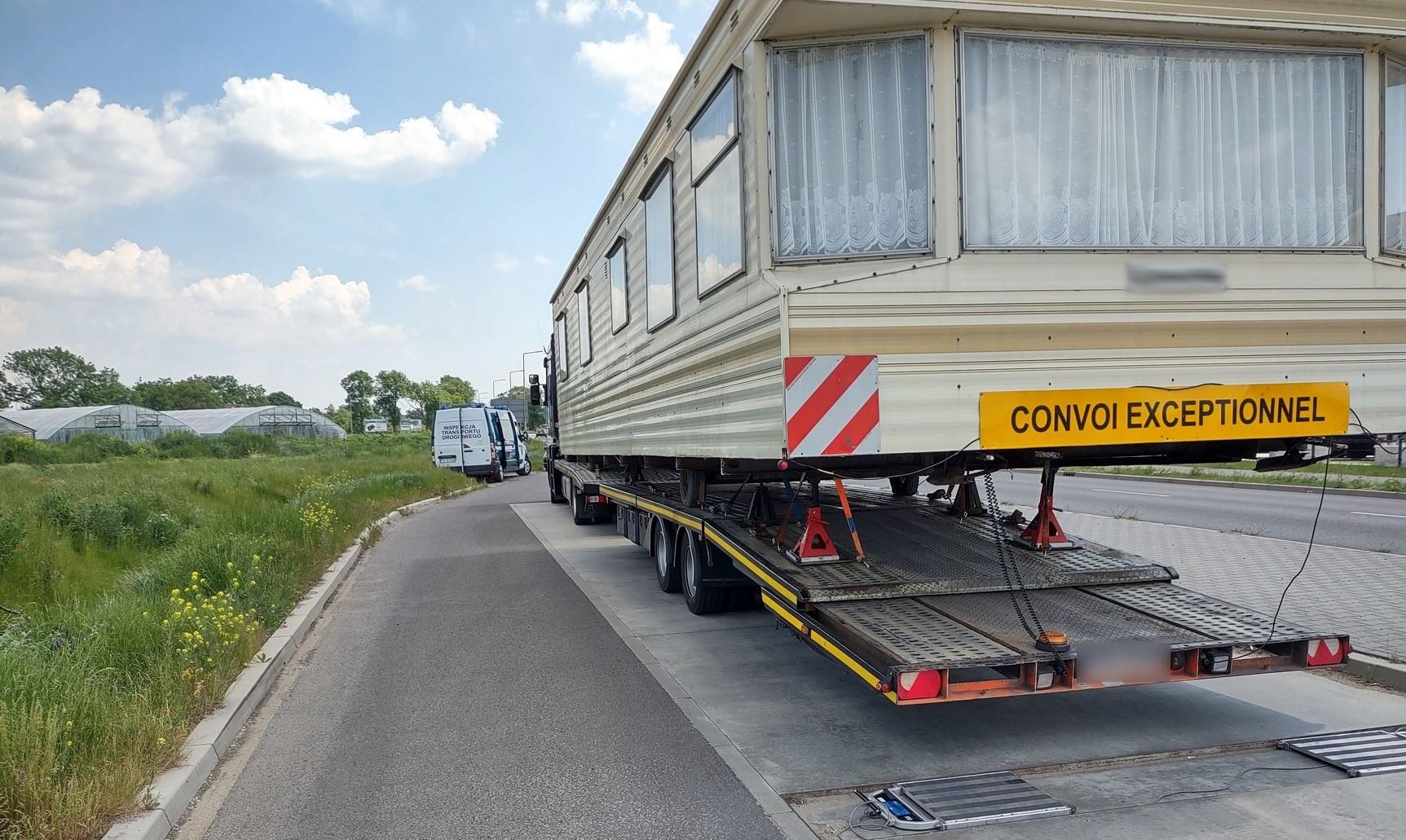 Zatrzymana do kontroli ciężarówka nienormatywna i stojący przed nią radiowóz ITD.