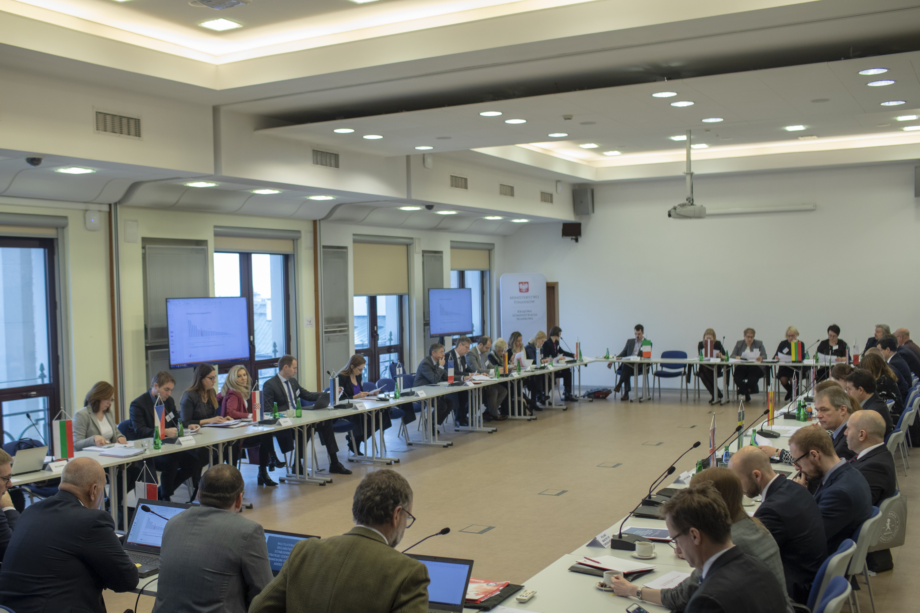 Uczestnicy spotkania w sprawie zwalczania mafii VAT siedzą przy stołach w sali konferencyjnej