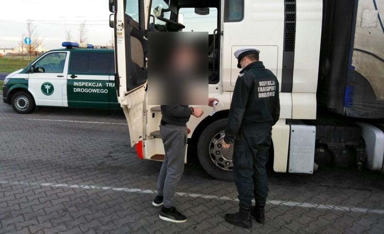 Inspektor kontroluje ciężarówkę i kierowcę.