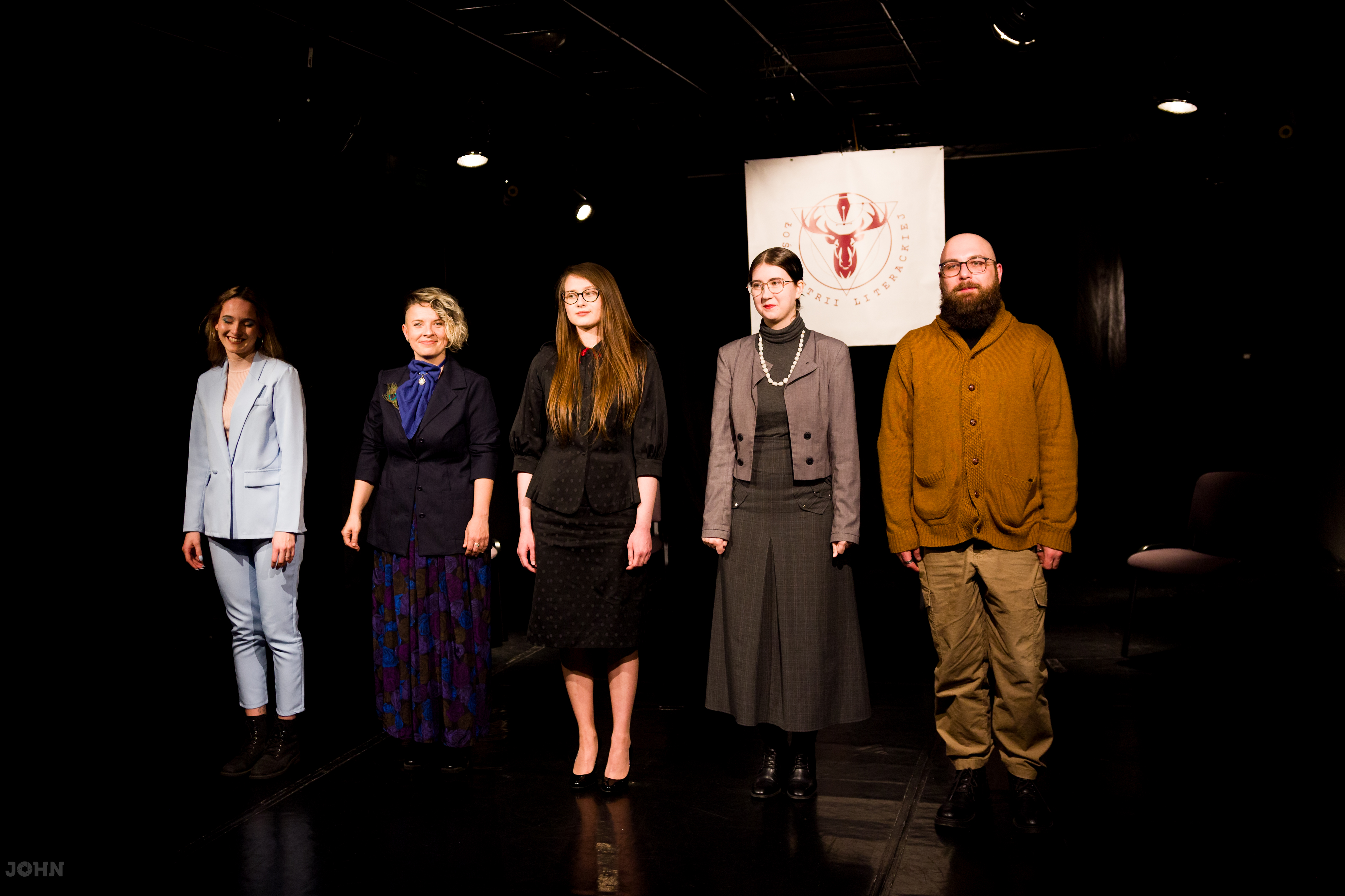 Pięcioro aktorów stojących na czarnej scenie teatralnej po spektaklu „Nad kobietami Lovborga” Woody Allen