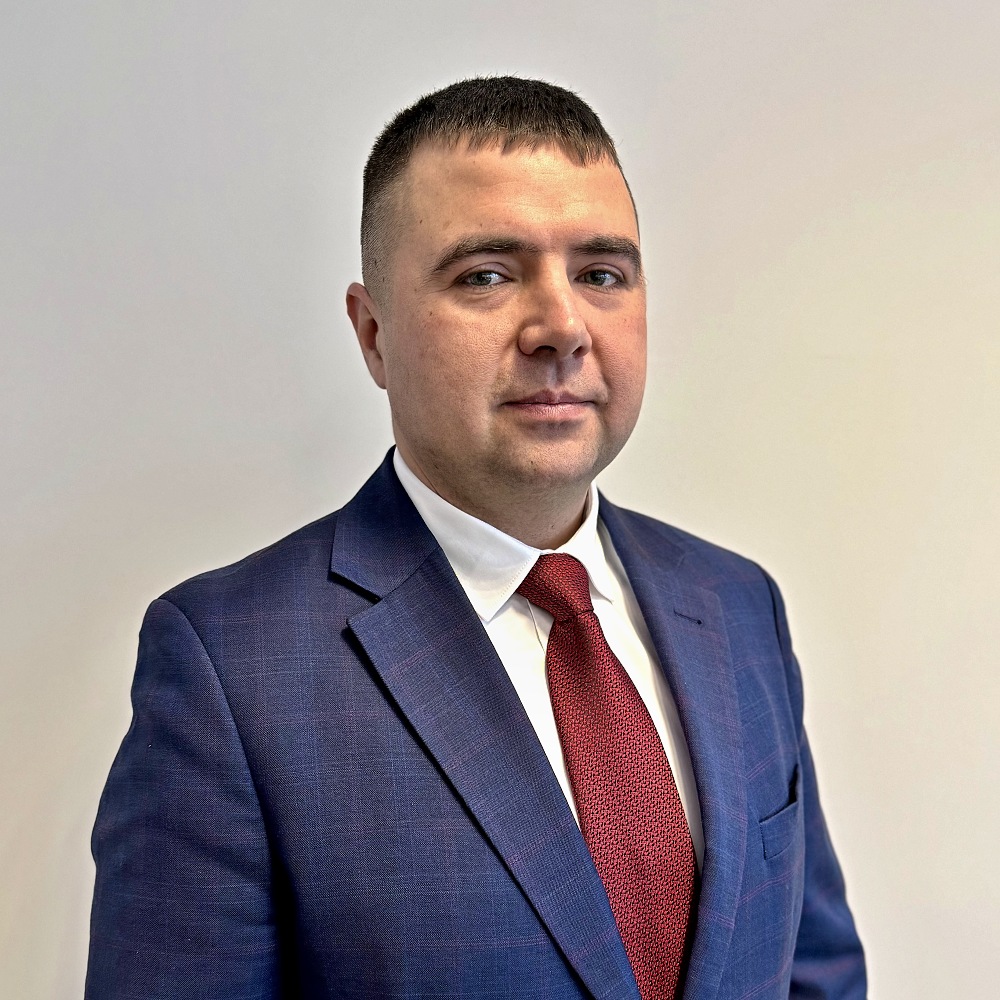 Portret mężczyzny w garniturze na jasnoszarym tle