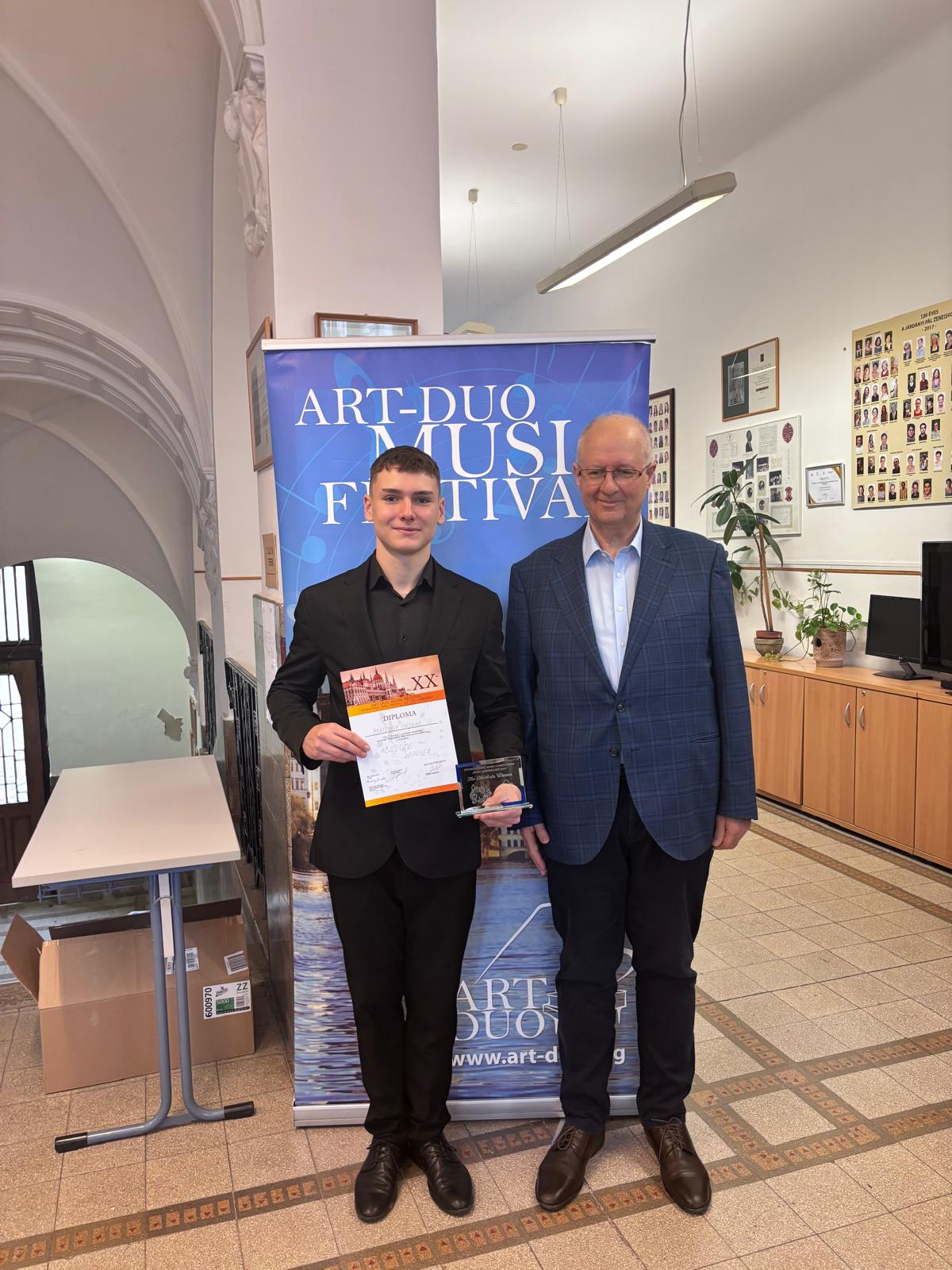 Mateusz Neckar, Andrzej Smolik. Uczeń i nauczyciel na tle baneru konkursu Art Duo