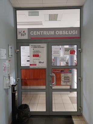 Wejście na salę obsługi a za drzwiami brązowa lada