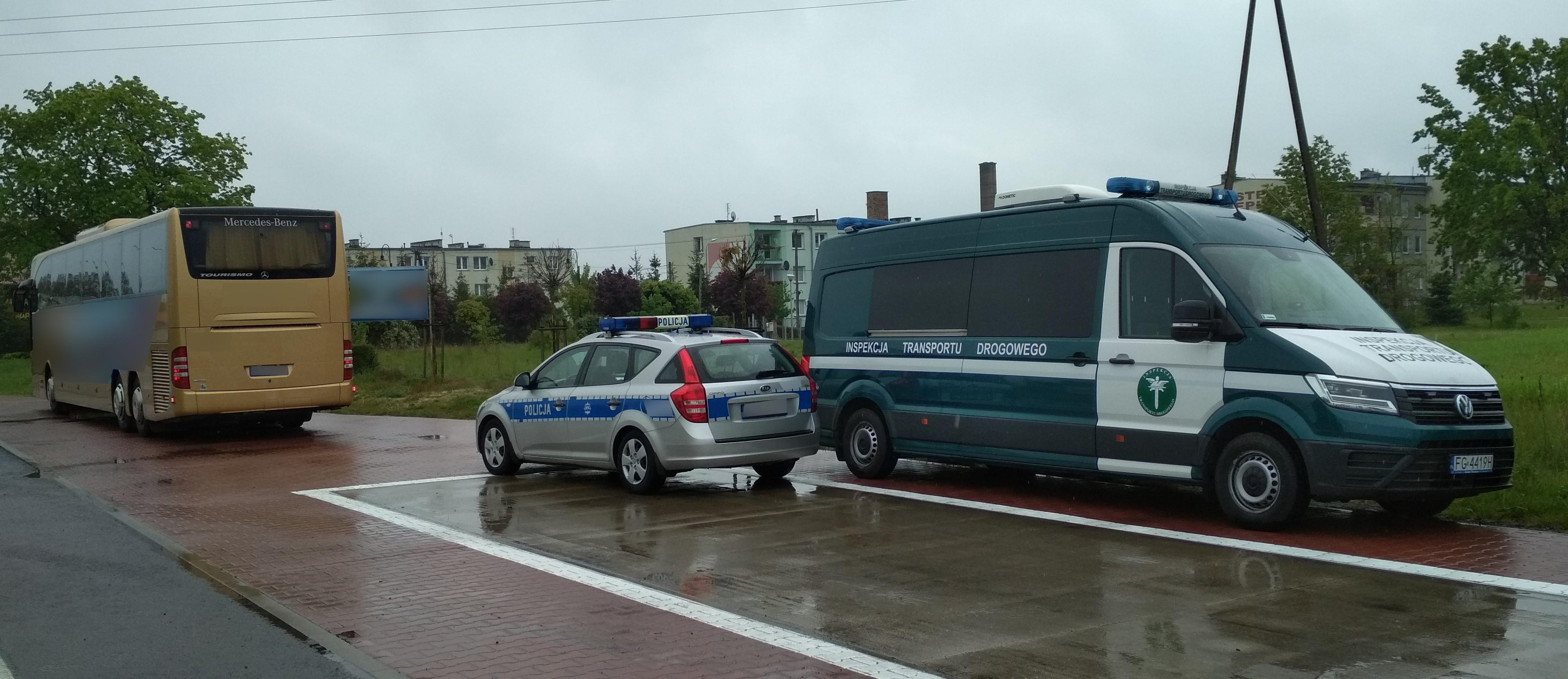 Radiowóz ITD i Policji obok brązowego autokaru