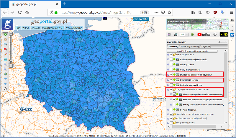 Ilustracja przedstawia zrzut z serwisu geoportal.gov.pl z widokiem całej Polski i zaznaczonymi warstwami ewidencji gruntów, sieci uzbrojenia terenu, planów zagospodarowania przestrzennego.
